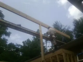 Carpenter setting a ridge beam over a new addition frame — Ice Dam Removal by Roofing Brothers in Harveyville