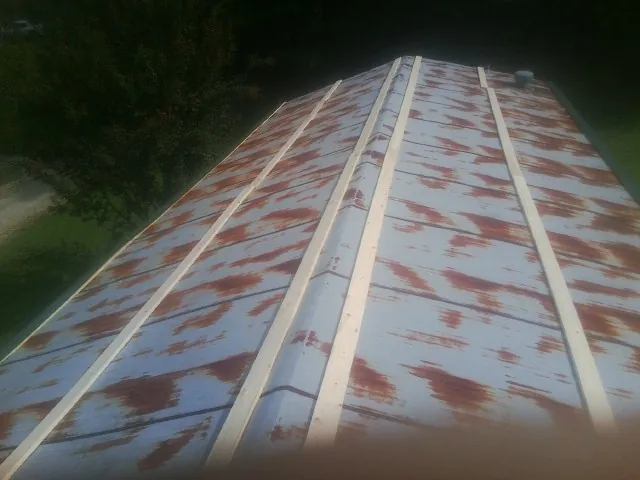 Rusted metal roof panels with new wood purlins before replacement — Storm Damage Roof Repair in Harveyville by Roofing Brothers