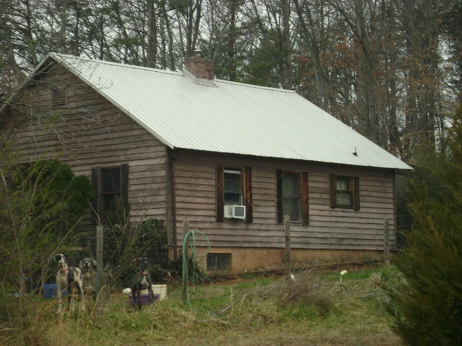 White metal roof on an old wood sided farmhouse, from a Metal Roof Installation job in Harveyville